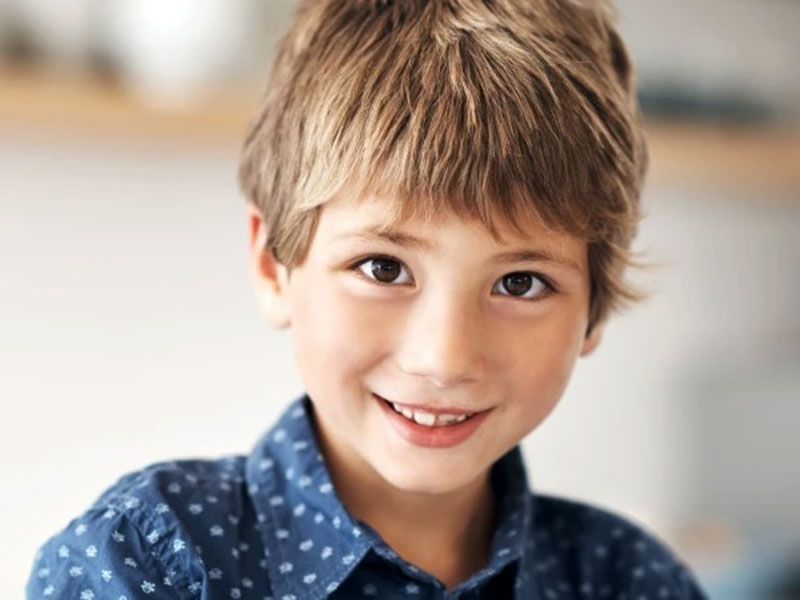 a boy in blue shirt smiling