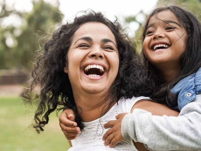 a daughter and his mother playing and smiling