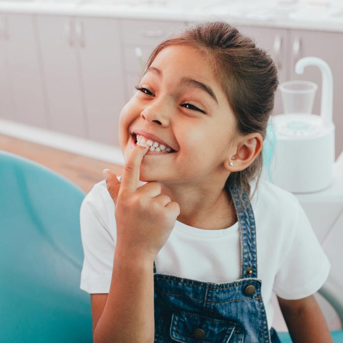 little girl pointing to teeth